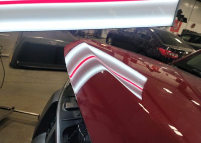 Repaired hood of a red car by MBT INC DBA Cheyenne Ding Guy in Cheyenne, WY.
